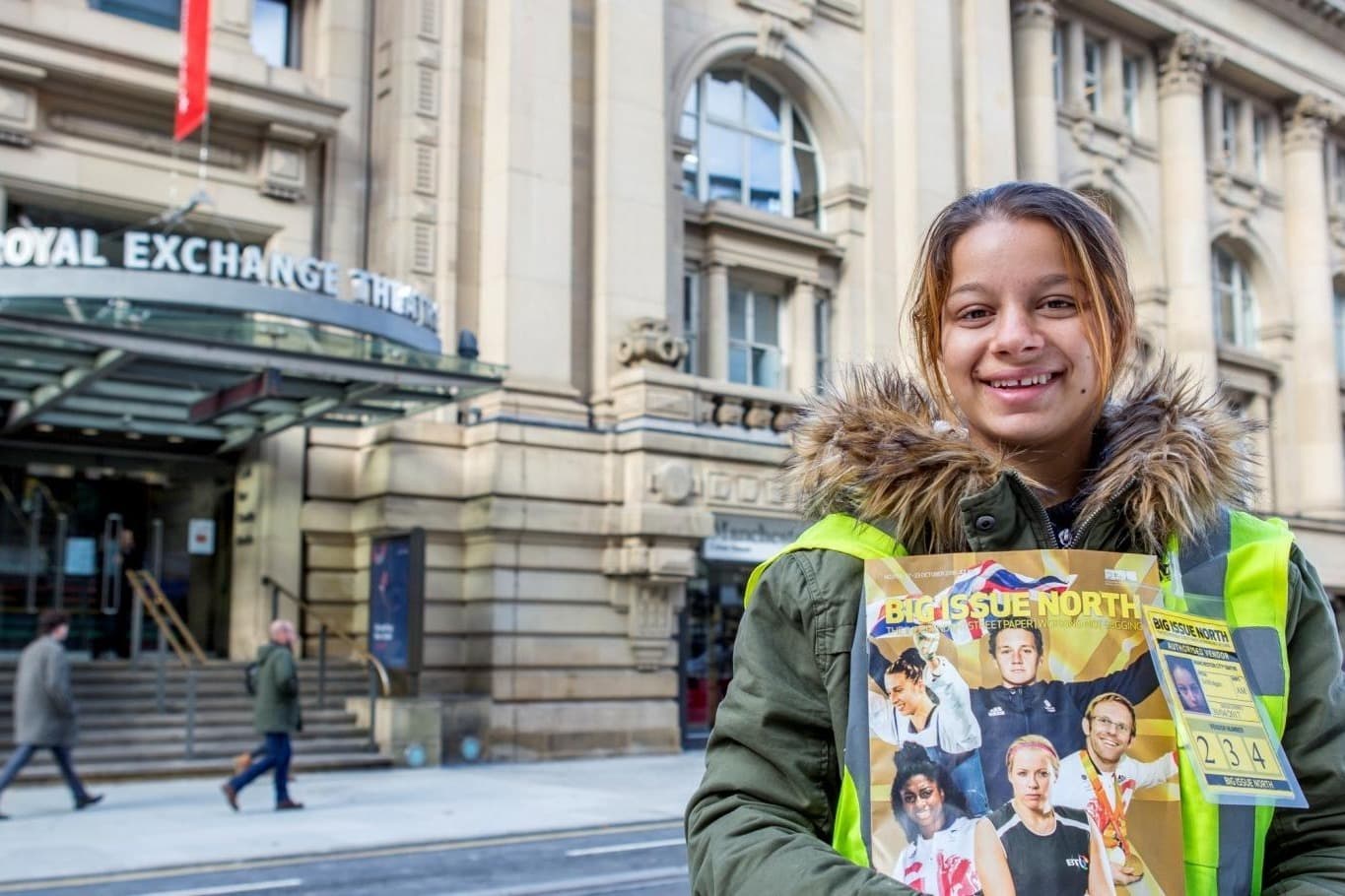 A woman smiling with big issue