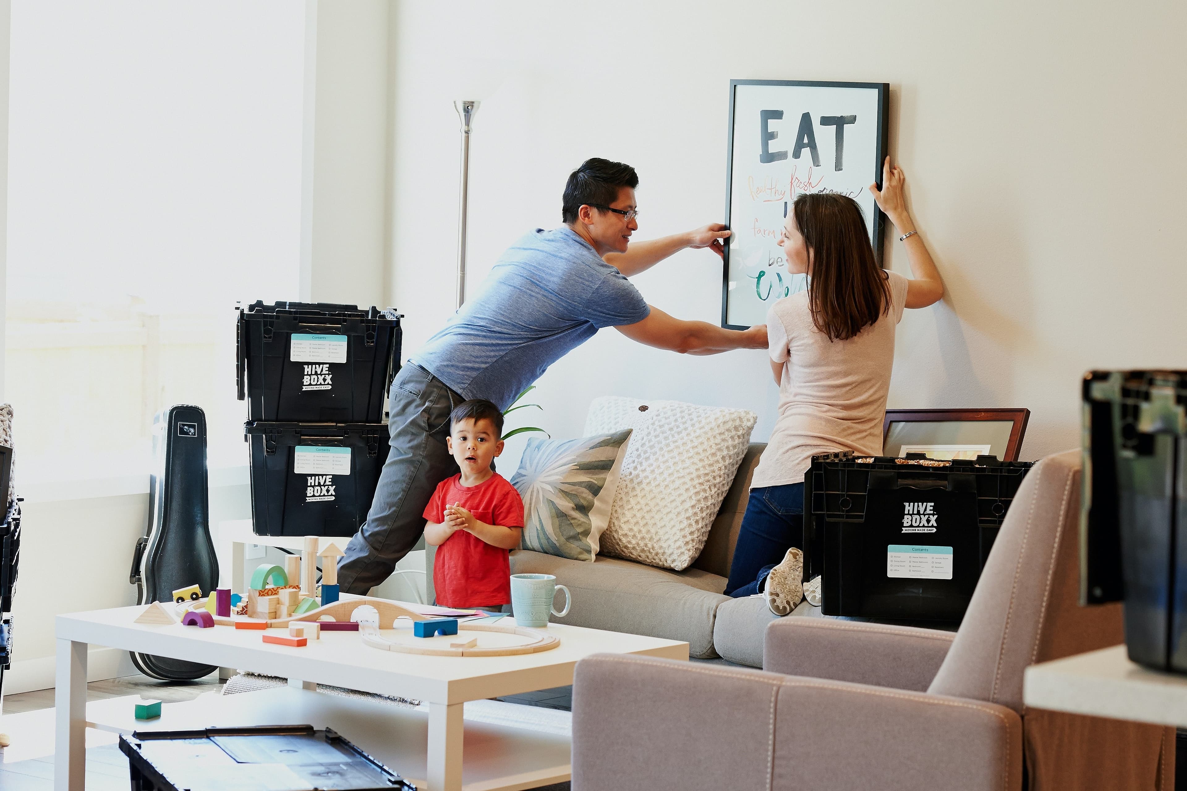 A family hanging up an image in their home
