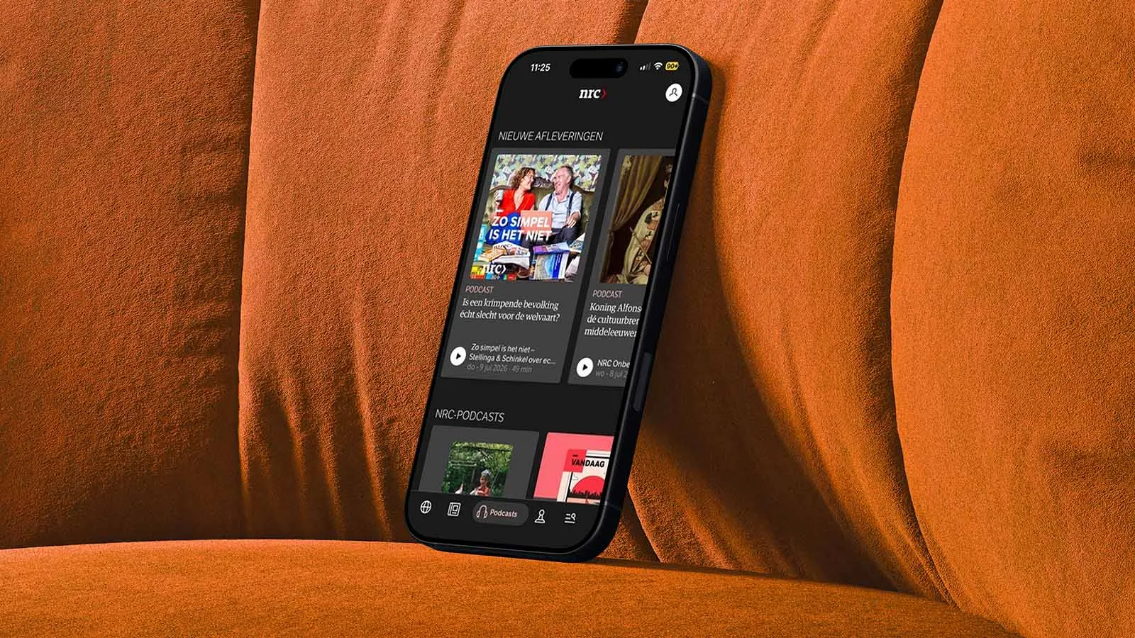 A phone displaying the NRC news app rests on an orange chair.