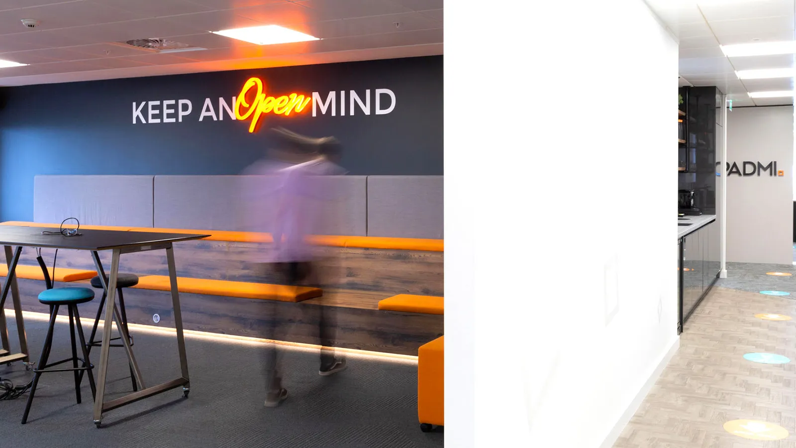 Apadmi office, showing a blurred man walking towards a sign that says 'Keep and Open Mind'