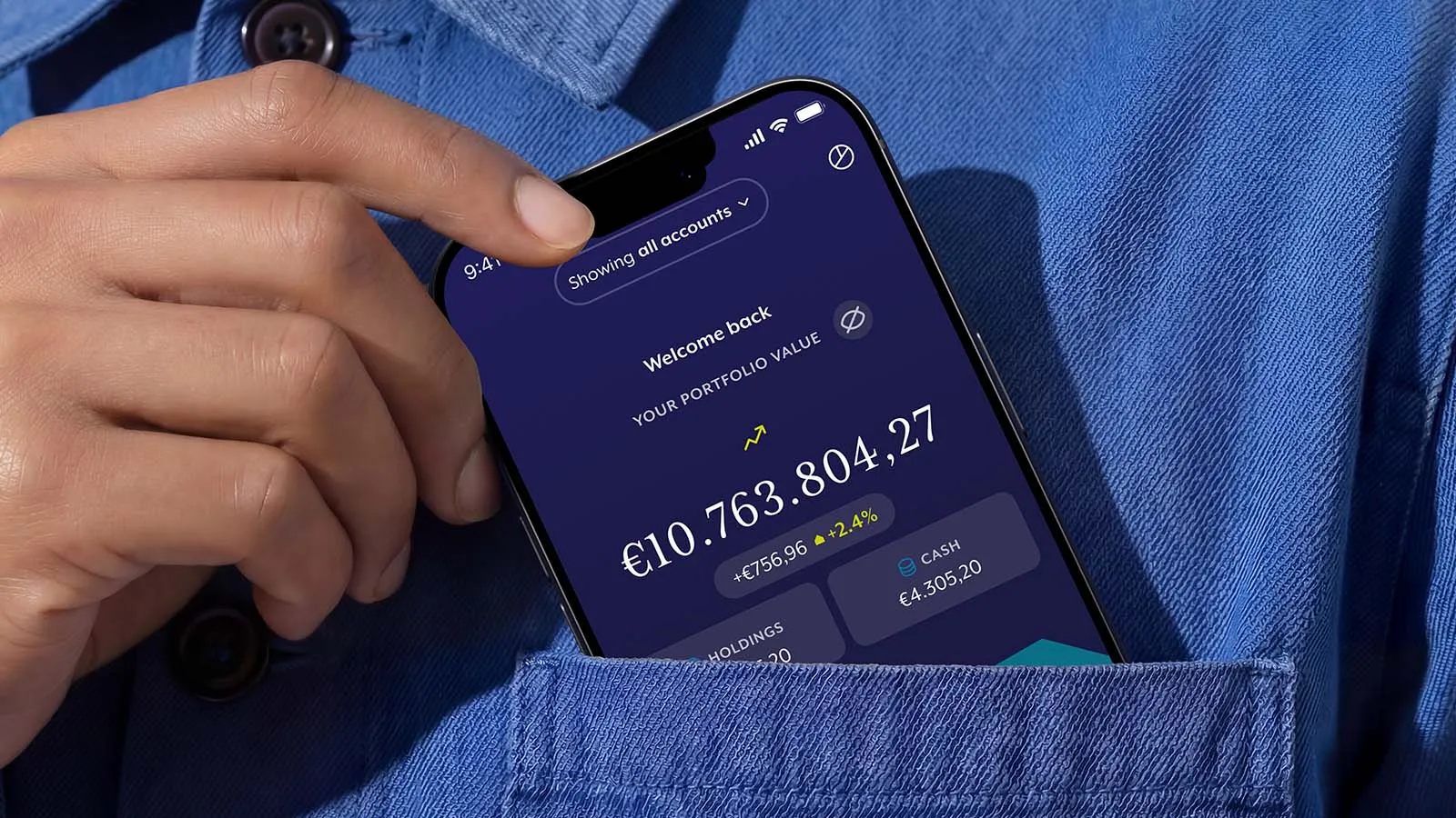 A phone peeks out of the top pocket of a blue shirt, displaying the Charles Stanley app.