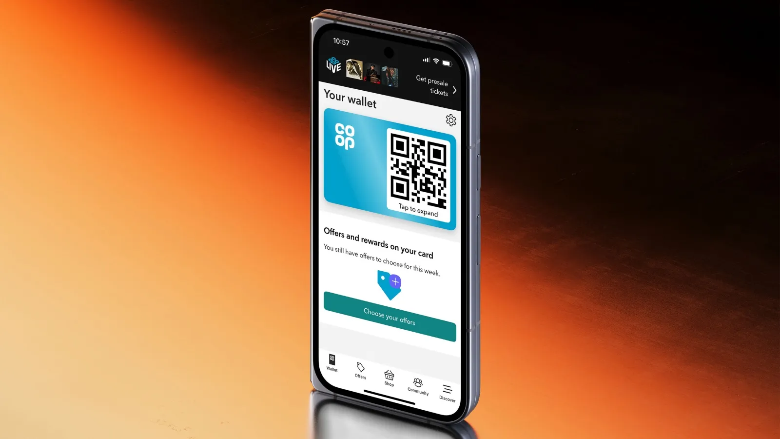 An upright mobile displaying the Co-op app, against an orange and black background.