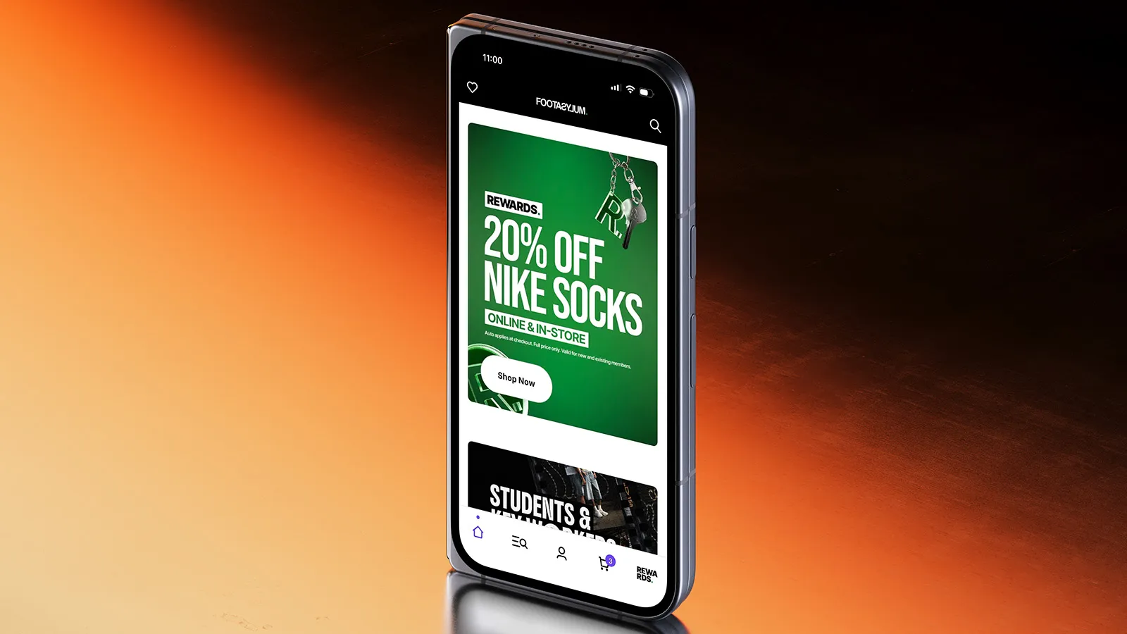 A phone displaying the Footasylum app on an orange and black background