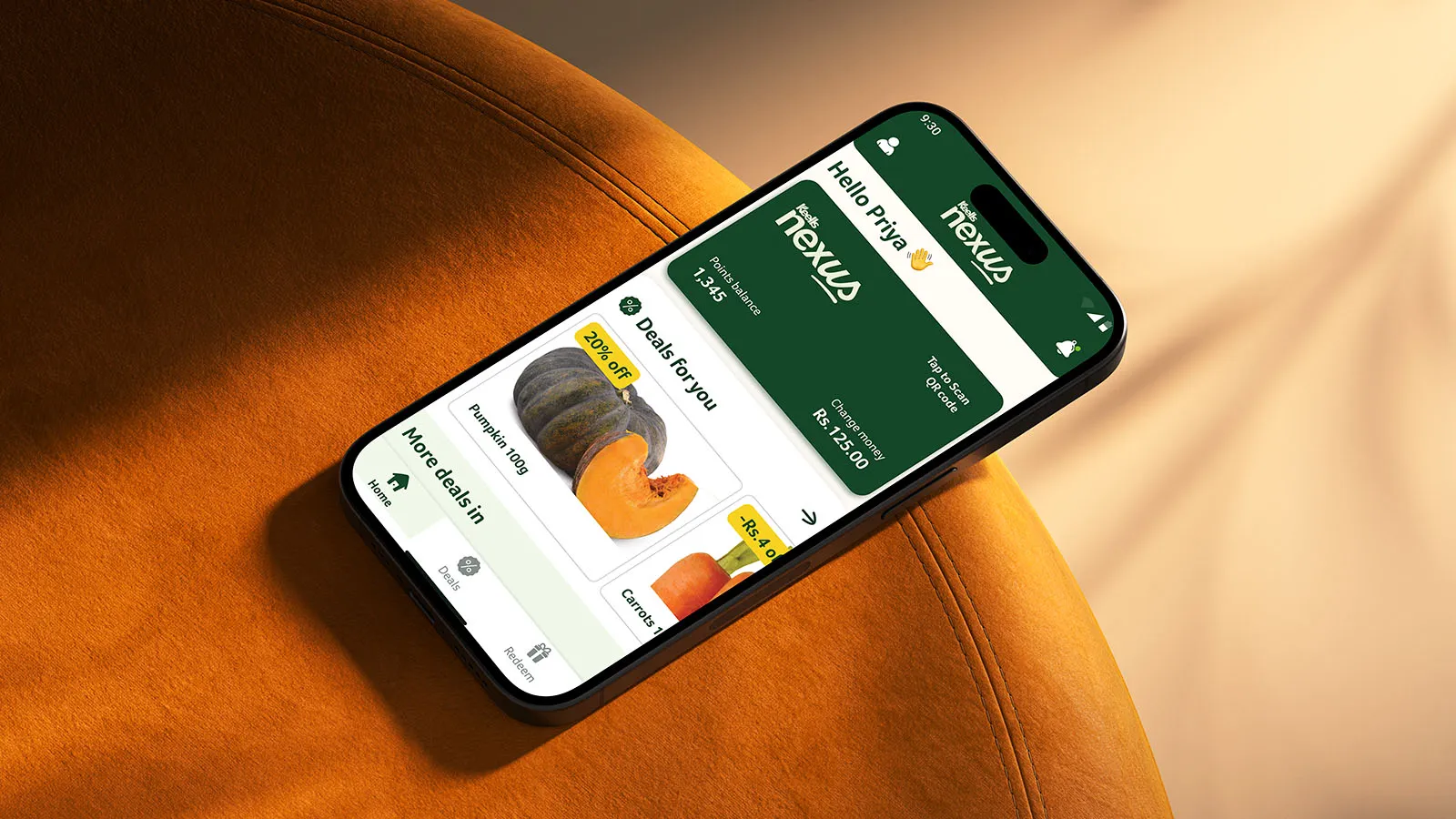 Keells app displayed on a mobile phone, lying on an orange chair.