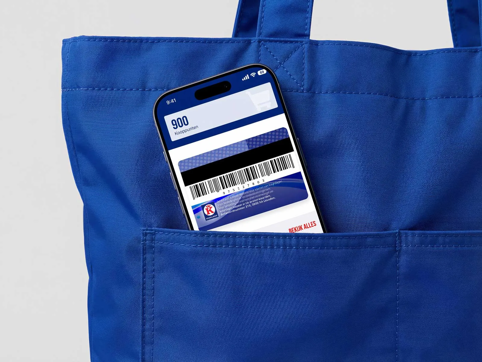Een iPhone steekt uit een blauwe boodschappentas en toont de Keurslager-app.