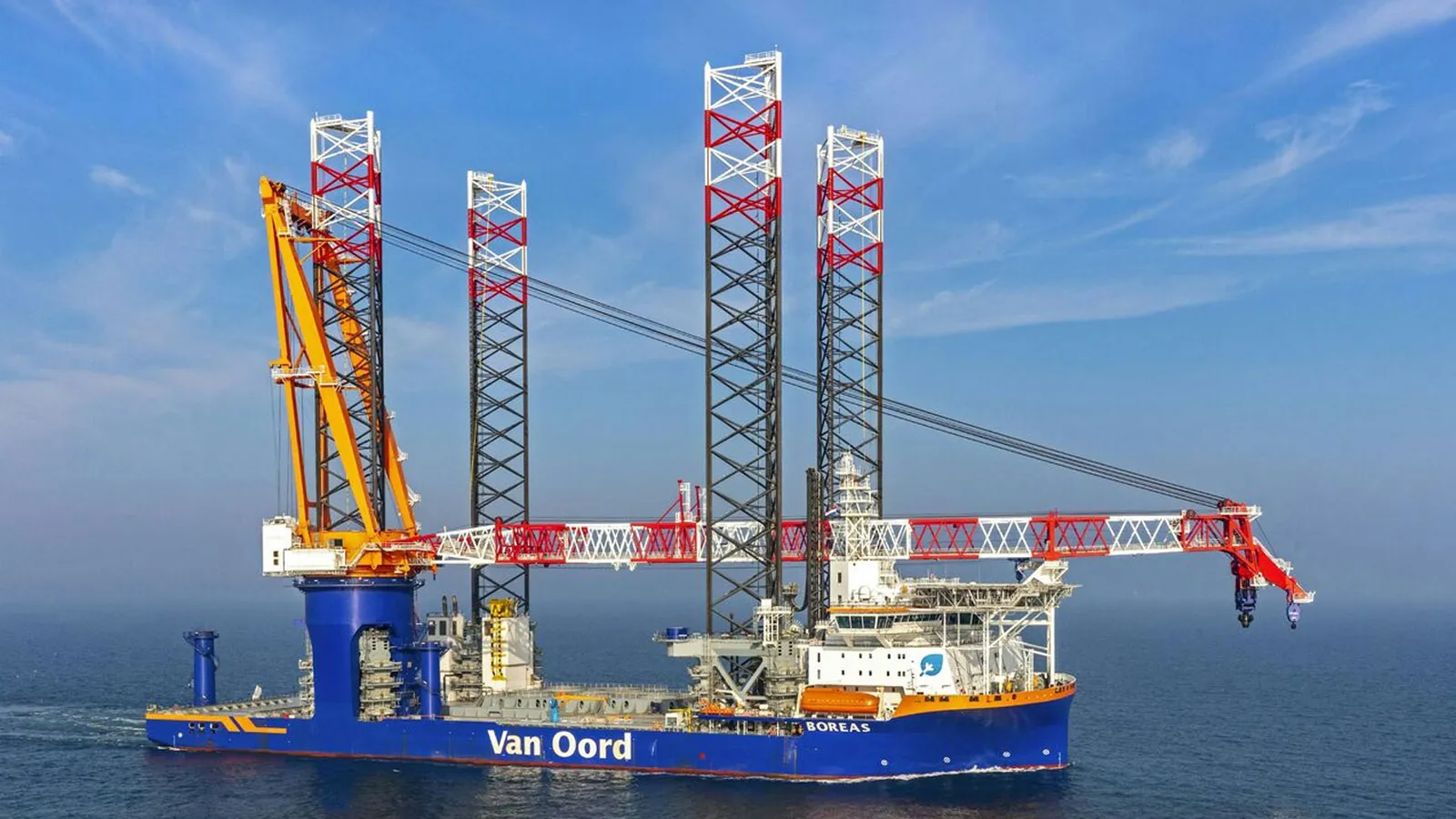 A Van Oord vessel with industrial equipment, against a backdrop of blue sea and sky.